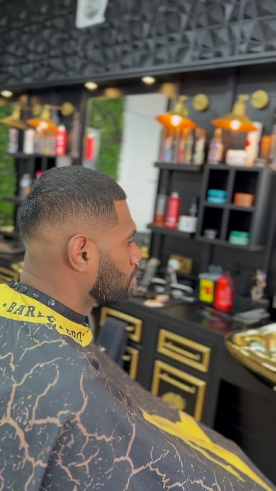 Short crop with a crisp beard line-up, side profile