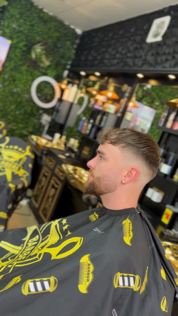 Textured crop with a skin fade and a shaped beard, side view, in the chair at Bonnie Barbers