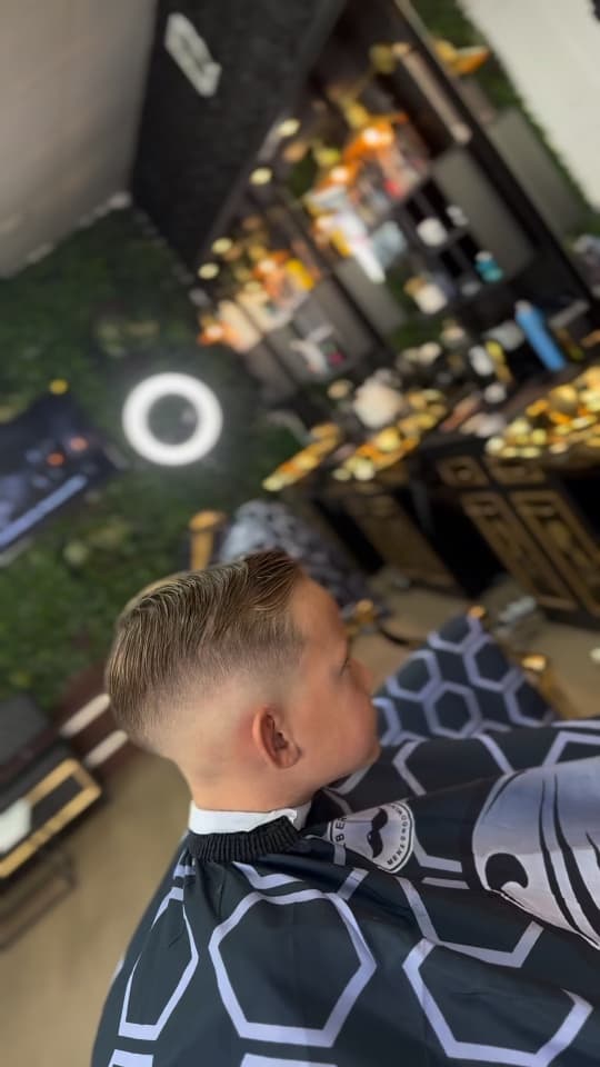 Boy's side part with a skin fade, side profile