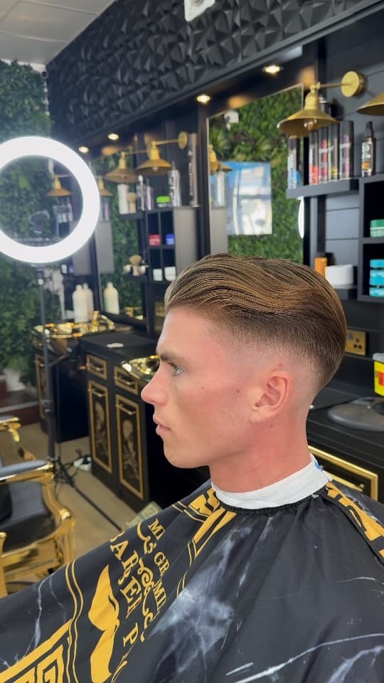 Skin fade with the top slicked back, side profile